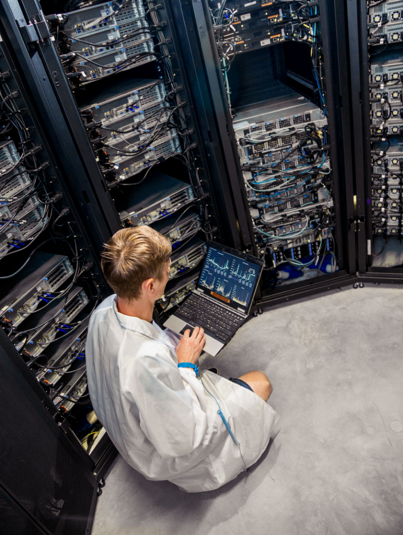 Man sat down next to data centre wiring